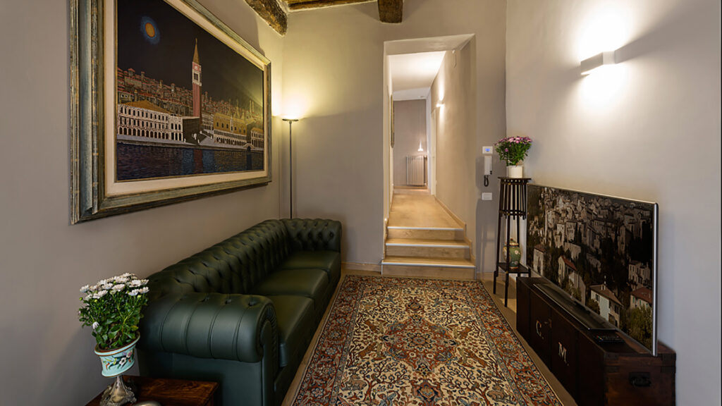 The living room with green leather sofa and paintings